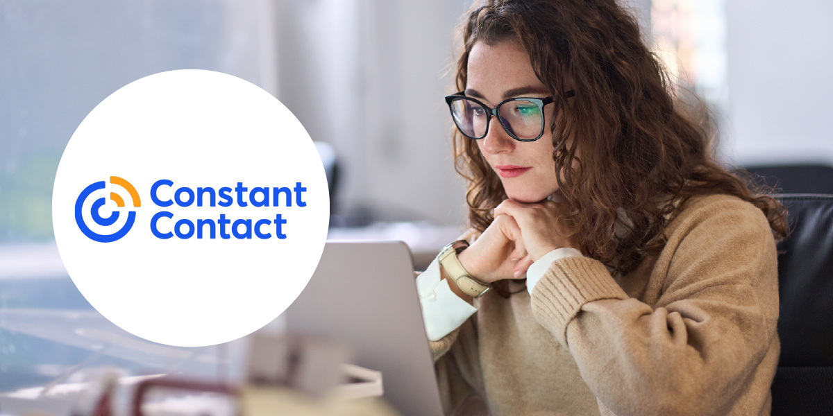 Office worker looking intently at their laptop. the Constant Contact logo is inset inside a white circle.