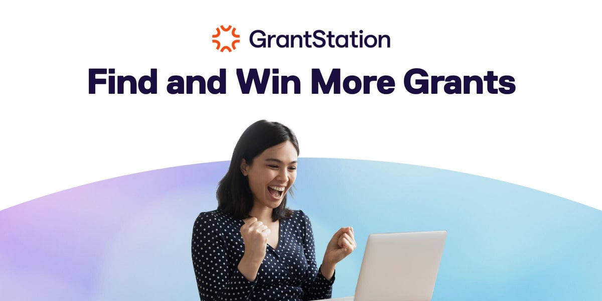 Photo of a person working at a laptop, pumping their fists after scoring grant funding. Text says, "GrantStation: Find and Win More Grants"