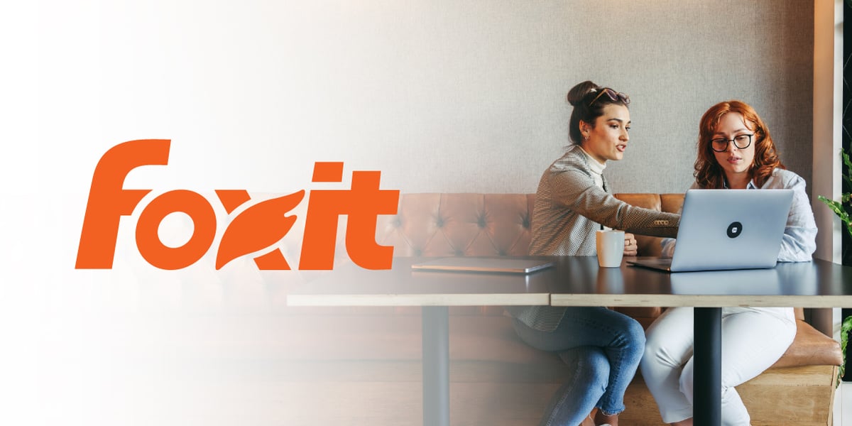 Foxit logo alongside a photo of two colleagues collaborating on a laptop.