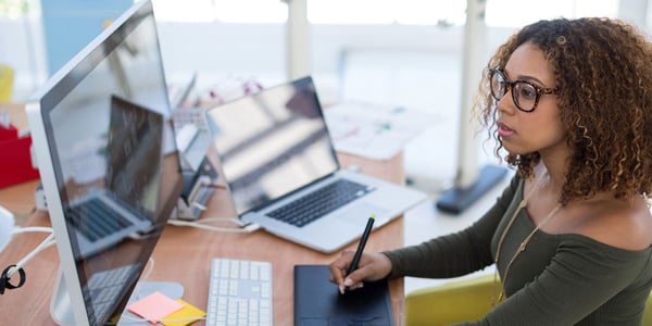 a woman making a flyer using Adobe Creative Cloud